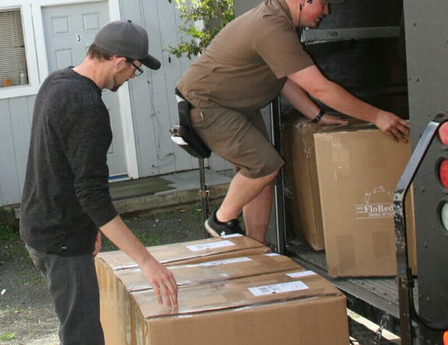 Delivery driver delivering a latex mattress from FloBeds